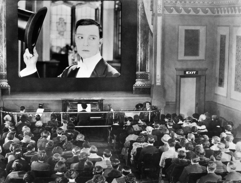 Svart-hvitt fotografi av en kinosal der publikum ser på en film med Buster Keaton (amerikansk stumfilmskuespiller) i New York, ca 1920.