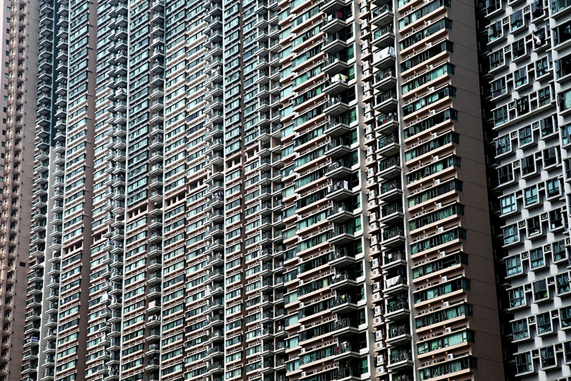Fotografi av en urban boligblokk med mange leiligheter over flere etasjer.