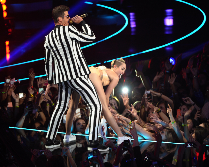 Fotografi av Miley Cyrus som twerker inntil Robin Thicke på scenen under MTV Video Music Awards i 2013.