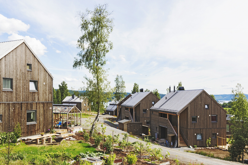 Fotografi av hus som ligger i Norges første økolandsby i Hurdal. Husene er bygget i naturmaterialer.