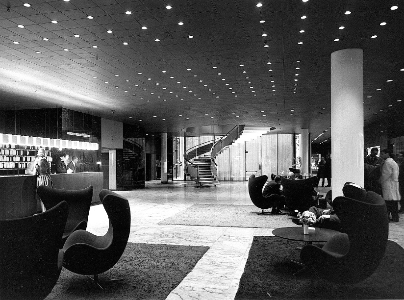 Svart-hvitt fotografi fra lobbyen i SAS Royal Hotel på 1960-tallet. Lobbyen er møblert med Egget-stoler designet av Arne Jacobsen.