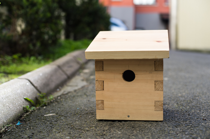 Fotografi av en fuglekasse som er laget av tre.