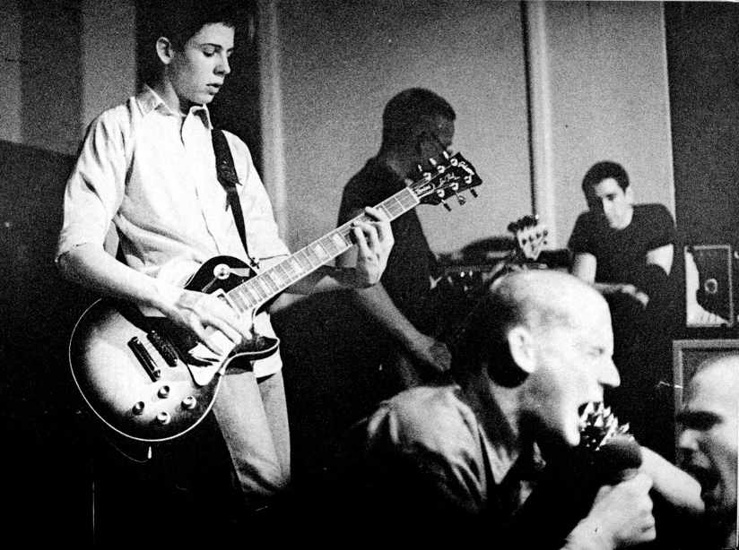 Svart-hvitt fotografi av Minor Threat som opptrer på The Wilson Center i Washington D.C. i 1981.