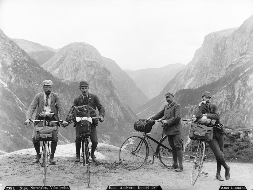 Svart-hvitt fotografi av fire menn på sykkeltur i Sogn og Fjordane i 1880-årene.